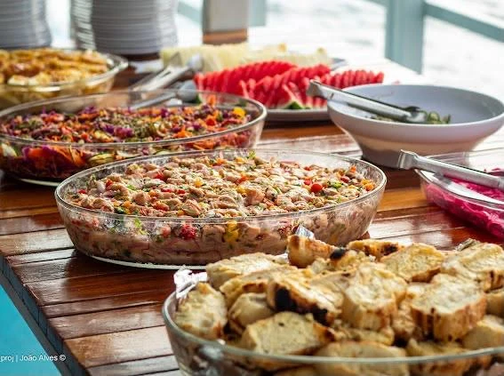 Mesa do buffet em Noronha com pratos, saladas e frutas